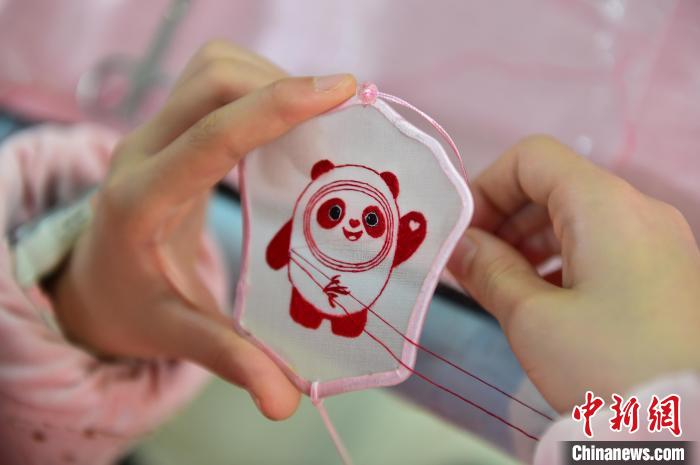 圖為一名小學(xué)生正在繡制2022年北京冬奧會吉祥物“冰墩墩”形象。　喻云亮 攝