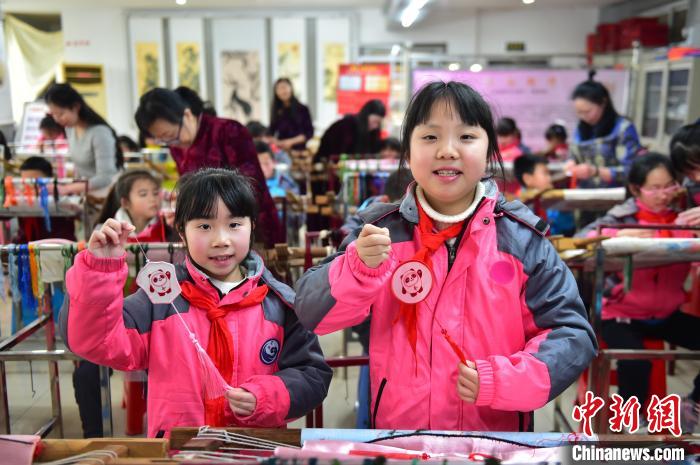 圖為小學(xué)生展示繡制好的2022年北京冬奧會吉祥物“冰墩墩”形象?！∮髟屏?攝