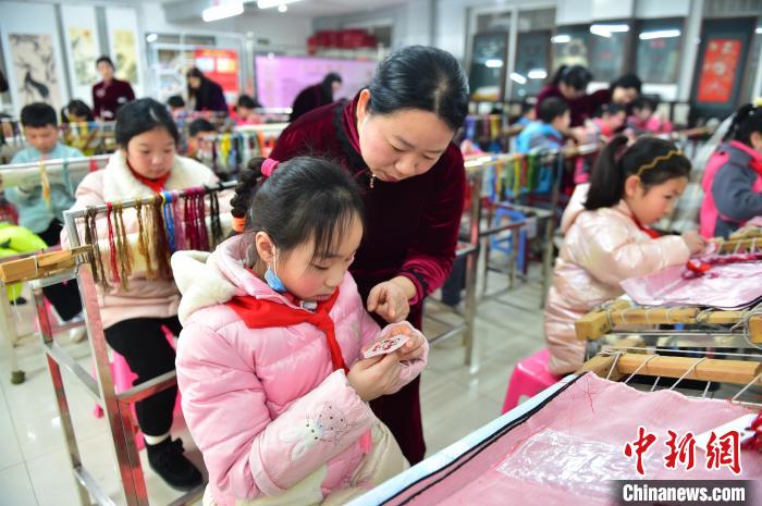 江西省級非遺豫章繡傳承人手把手指導(dǎo)小學(xué)生繡制2022年北京冬奧會吉祥物“冰墩墩”形象?！∮髟屏?攝