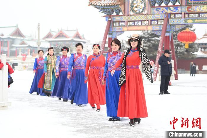 2月13日，老年人在呼和浩特市大召?gòu)V場(chǎng)拍照“打卡”?！⑽娜A 攝