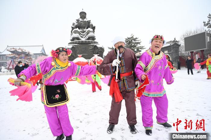 2月13日，秧歌隊(duì)在呼和浩特市大召?gòu)V場(chǎng)雪中起舞?！⑽娜A 攝