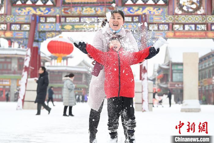 2月13日，家長(zhǎng)與小朋友在呼和浩特市大召?gòu)V場(chǎng)享雪趣。　劉文華 攝