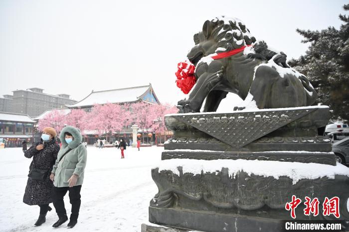 2月13日，民眾在呼和浩特市大召?gòu)V場(chǎng)雪中漫步。　劉文華 攝