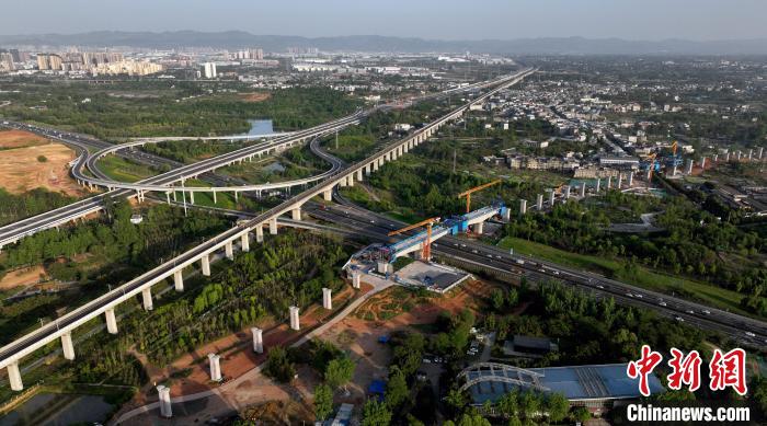 航拍正在建設(shè)的跨越成都繞城高速公路連續(xù)梁施工現(xiàn)場(chǎng)，旁邊依次為已運(yùn)營(yíng)的成渝高速鐵路和機(jī)場(chǎng)高速公路?！⒅铱?攝