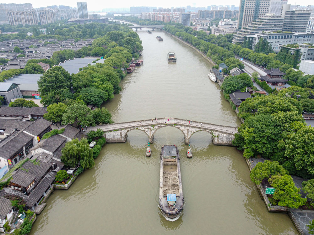 5月27日，一艘貨船駛過京杭大運河南端標志建筑杭州拱宸橋。(無人機照片)新華社記者江漢 攝