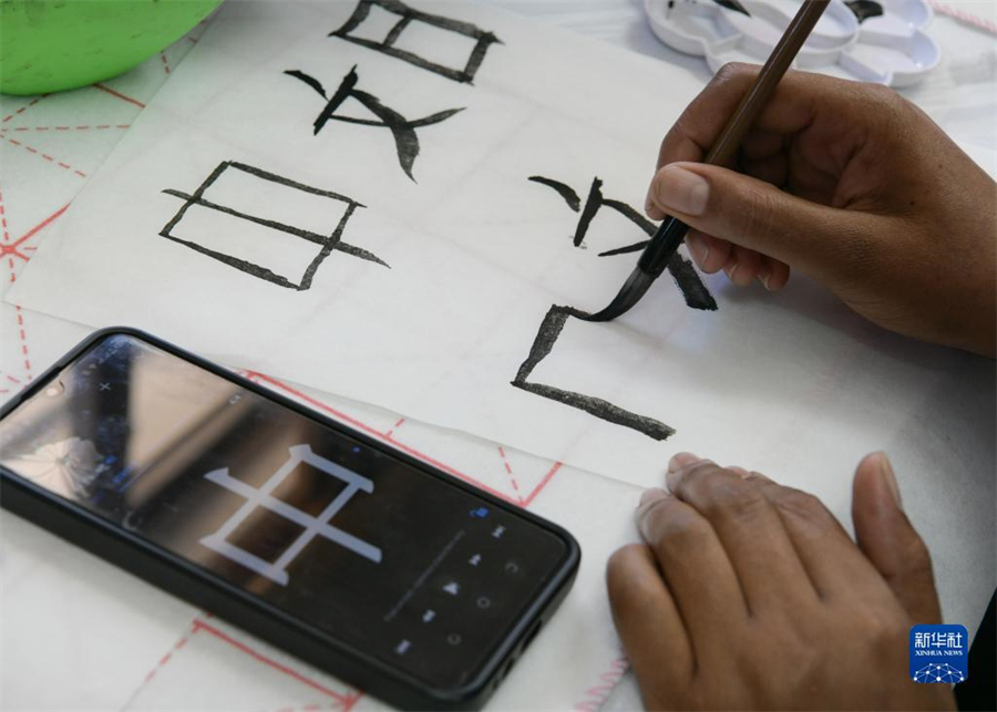 4月18日，肯尼亞學生在內羅畢大學孔子學院舉辦的活動上寫毛筆字。肯尼亞內羅畢大學孔子學院18日舉辦“中文，增進文明對話”主題活動，慶祝即將到來的第14個聯合國中文日。肯尼亞學生參與互動，進行書法、剪紙、唱中文歌等活動。新華社記者 韓旭 攝