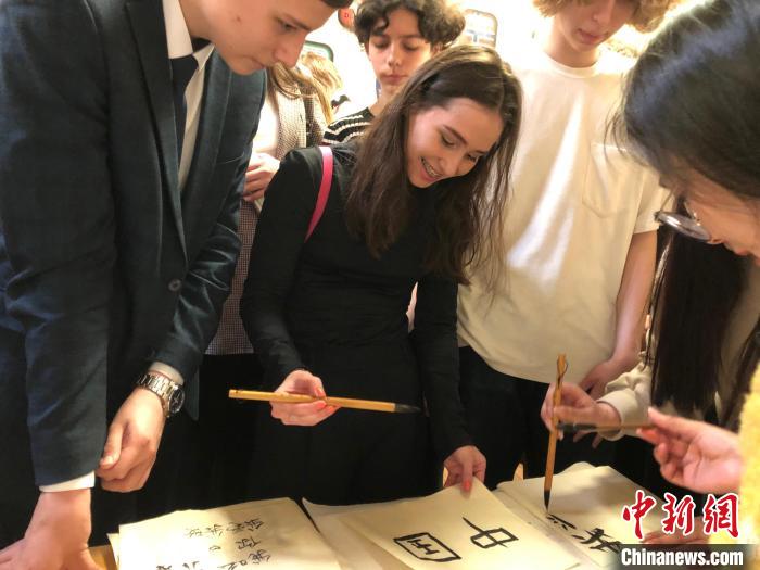 4月21日，莫斯科國立語言大學(xué)孔子學(xué)院附屬中學(xué)舉辦“國際中文日”活動(dòng)，學(xué)生們學(xué)寫漢字?！∧箍茋⒄Z言大學(xué)孔子學(xué)院 供圖