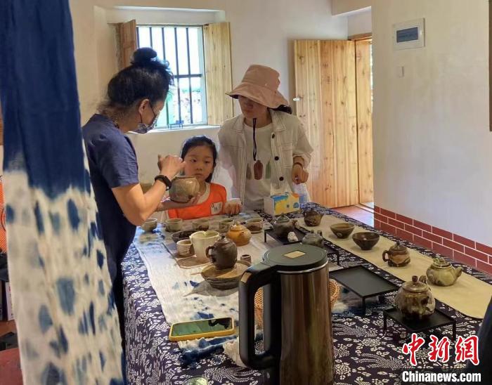 圖為：游客正在咨詢臺(tái)灣柴燒作品。　葉秋云 攝