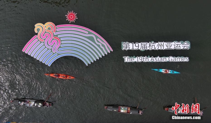 資料圖為烏篷船和皮劃艇從杭州亞運(yùn)會(huì)標(biāo)識(shí)前劃過。王剛 攝