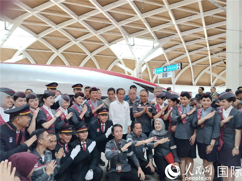 印尼總統(tǒng)佐科與雅萬(wàn)高鐵乘務(wù)員及中印尼嘉賓合影。人民網(wǎng)記者 李培松攝