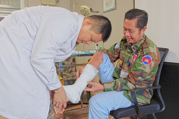 中國第22批赴黎維和醫(yī)療分隊軍醫(yī)為患者打石膏固定患肢。李清竹攝