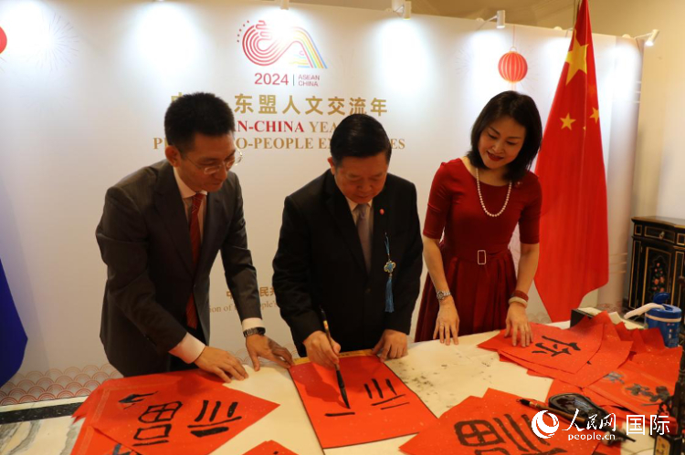 東盟秘書(shū)長(zhǎng)高金洪（中）在活動(dòng)現(xiàn)場(chǎng)寫(xiě)福字。人民網(wǎng)記者曹師韻攝