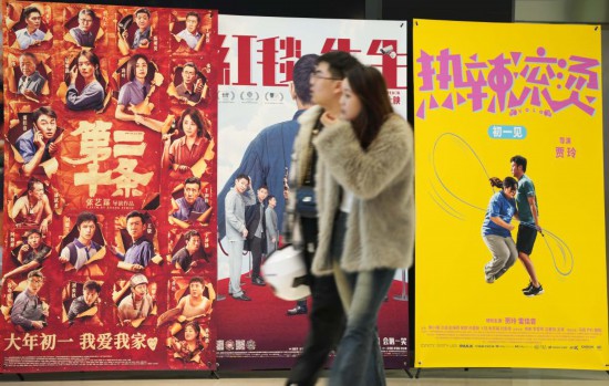 這是2月17日，在沈陽一家影院，觀眾從海報前經(jīng)過。新華社記者李鋼攝