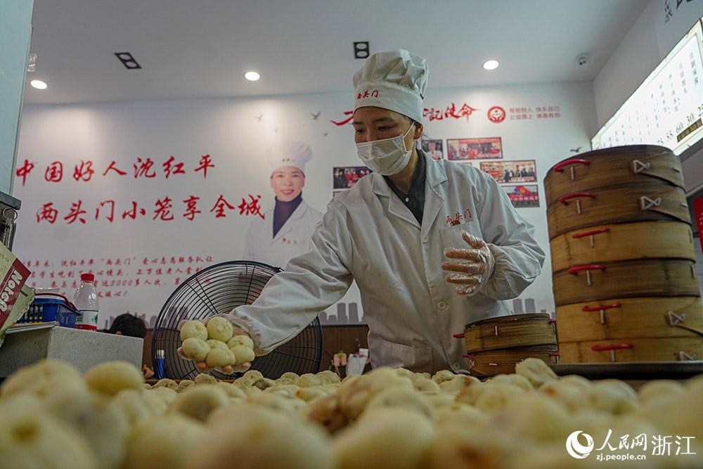 3月31日，在浙江省嵊州市甘霖鎮(zhèn)，嵊州小吃從業(yè)者沈紅平把蒸熟的小籠包晾涼，打包冷藏售賣。人民網(wǎng) 章勇濤攝