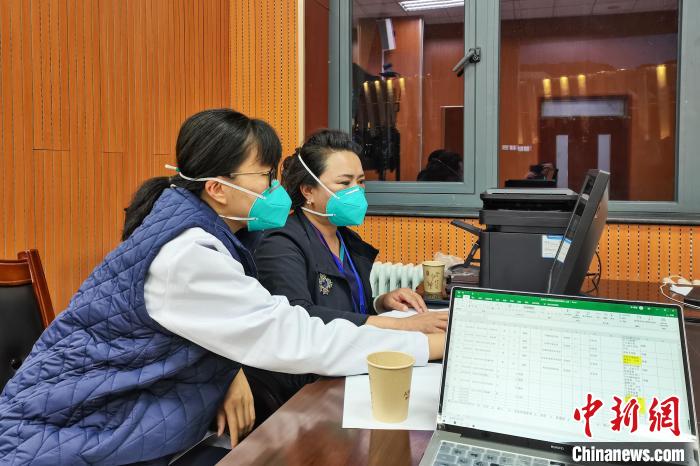 8月9日，楊蘇喬(左)在拉薩方艙醫(yī)院指揮部讀取艙內(nèi)患者胸部CT?！∈茉L者供圖