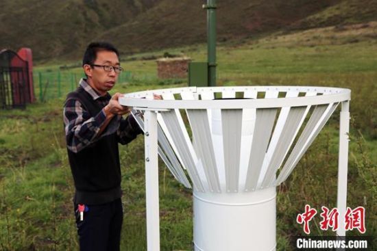 圖為班瑪縣氣象局工作人員在維護(hù)藏雪茶基地氣候站。青海省氣象局供圖