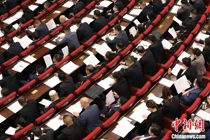圖為會議現(xiàn)場，參會代表正在聽取政府工作報告?！∑钤鲚?攝