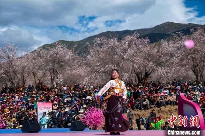 桃花林下精彩的“桃花仙子”選拔吸引村民或游客。　劉忠俊 攝