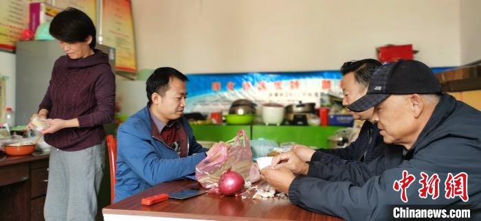 圖為扶貧路上“臨時(shí)一家人”準(zhǔn)備午餐?！∥航ㄜ?攝