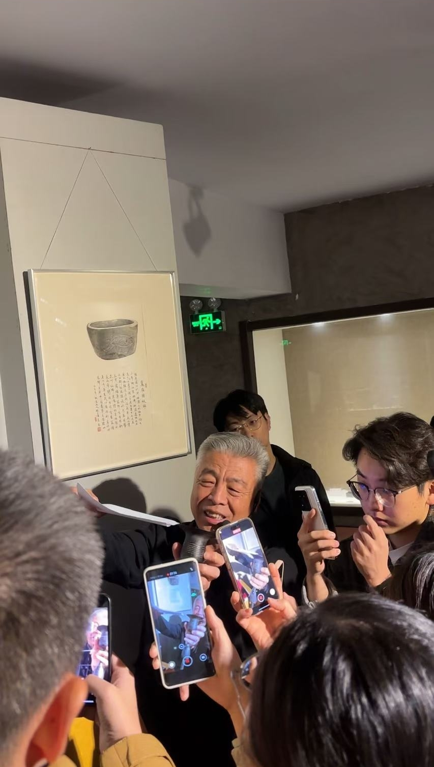 黑陶邢文化博物館館長邢葆東展示兩張相疊的A4紙，向記者解釋此為杯口的厚度。