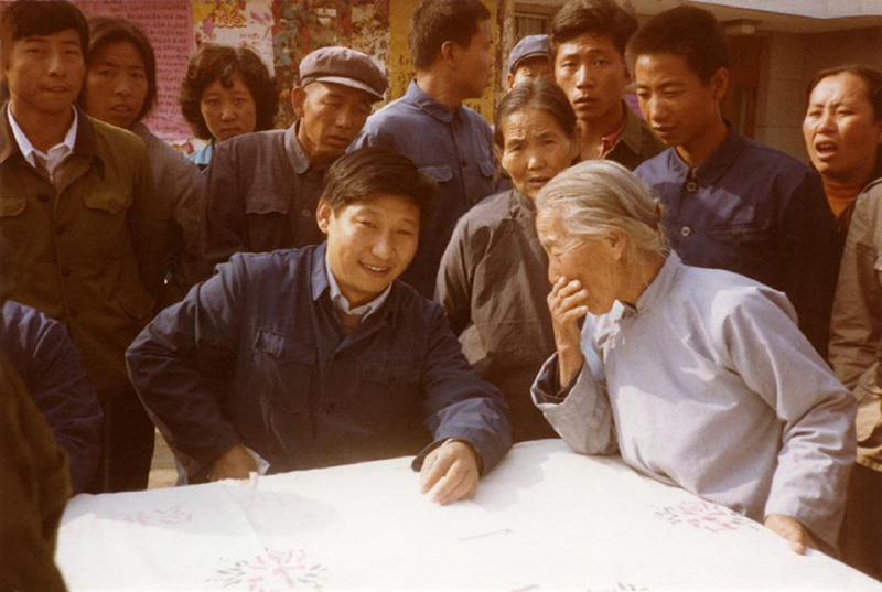 1983年，時(shí)任河北正定縣委書記的習(xí)近平（前排居中），臨時(shí)在大街上擺桌子聽取老百姓意見。