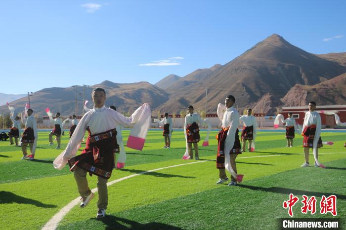 圖為青海師范大學(xué)附屬玉樹實驗學(xué)校學(xué)生在綠茵場跳起囊謙古舞—卓根瑪?！〕逃?攝