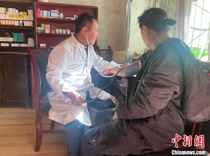 索木滾(左)為村民看病?！∪捞量h委宣傳部供圖