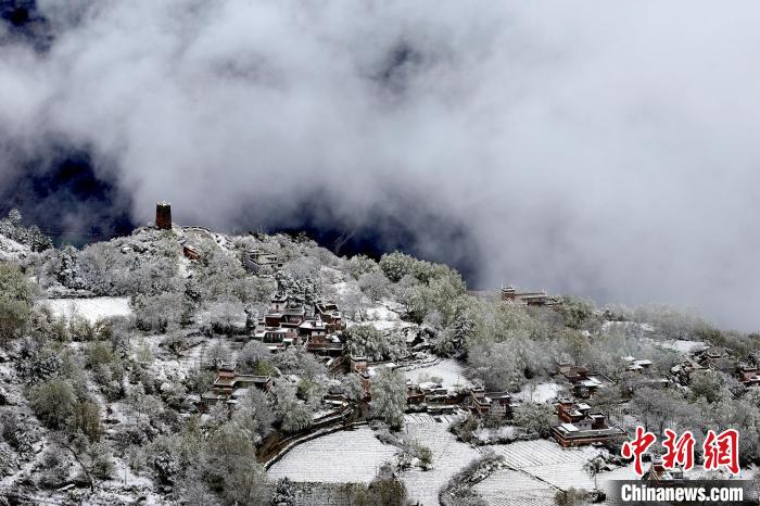 雪后的藏寨和碉樓構(gòu)成美麗的雪景?！〗党鯘衫?攝