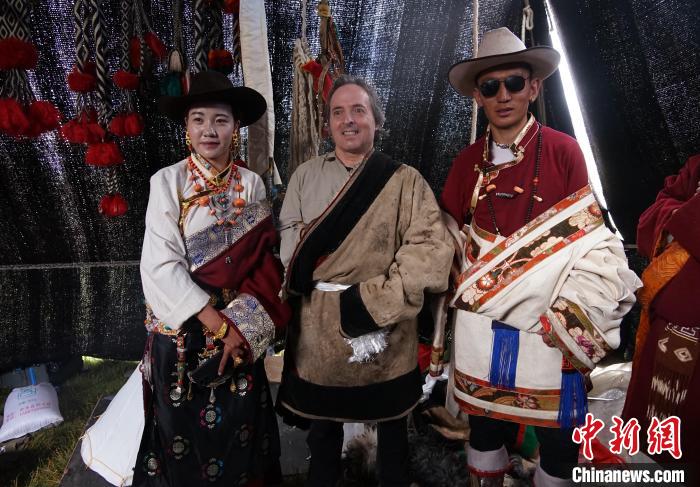 圖為一名外籍?dāng)z影師(中)身穿藏服和藏族民眾合影留念。　馬銘言 攝