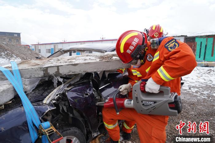 圖為地震實戰(zhàn)拉動現(xiàn)場，參演人員進行車輛破拆?！∮駱湎拦﹫D