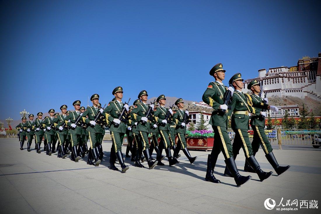 國旗護(hù)衛(wèi)隊(duì)隊(duì)員緊握鋼槍，踏著威武雄壯的步伐，走向國旗臺(tái)。人民網(wǎng) 次仁羅布攝