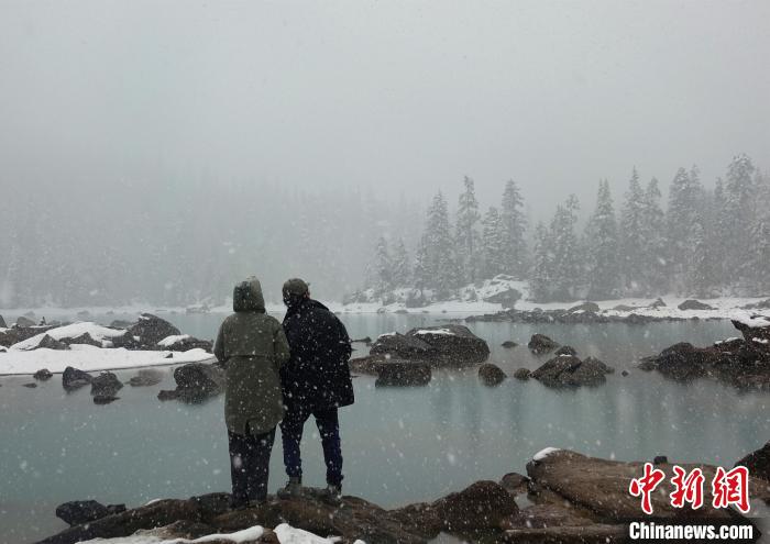 游客欣賞雪中然烏湖。　冉文娟 攝