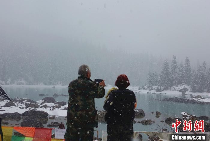 游客欣賞雪中然烏湖。　冉文娟 攝