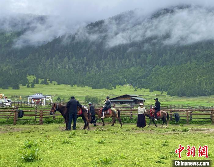 6月10日，游客在魯朗小鎮(zhèn)高山牧場(chǎng)景區(qū)體驗(yàn)騎馬?！∪轿木?攝