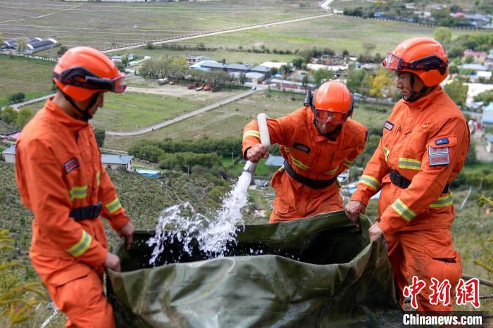 技能大練兵過程中，消防員在陡坡上向蓄水池注水?！±顕鵂c 攝