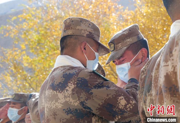 圖為什布奇邊防連退伍老兵與戰(zhàn)友相擁而泣，依依惜別?！⌒觳?攝