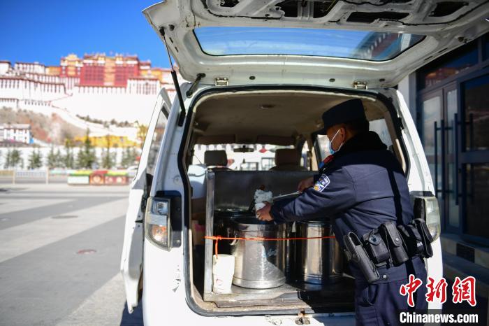 圖為1月23日，布達(dá)拉宮廣場(chǎng)派出所民警正在打午飯?！∝暩聛?lái)松 攝