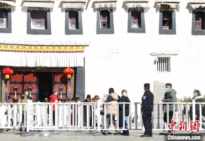 圖為1月23日，布達(dá)拉宮廣場(chǎng)派出所民警正在引導(dǎo)游客?！∝暩聛?lái)松 攝