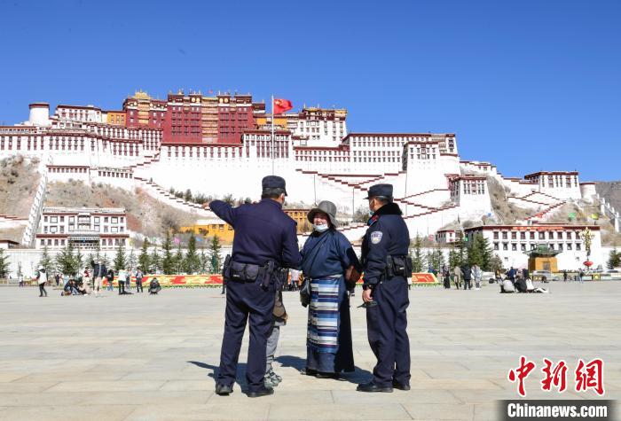 圖為1月23日，布達(dá)拉宮廣場(chǎng)派出所民警正在回答民眾咨詢(xún)?！∝暩聛?lái)松 攝
