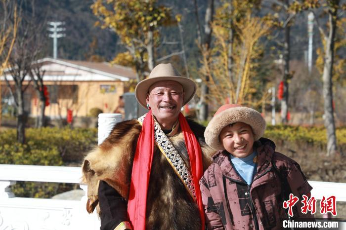 圖為林芝市巴宜區(qū)布久鄉(xiāng)仲果村村民桑杰與孫子一起參加藏歷新年活動(dòng)?！埩?攝