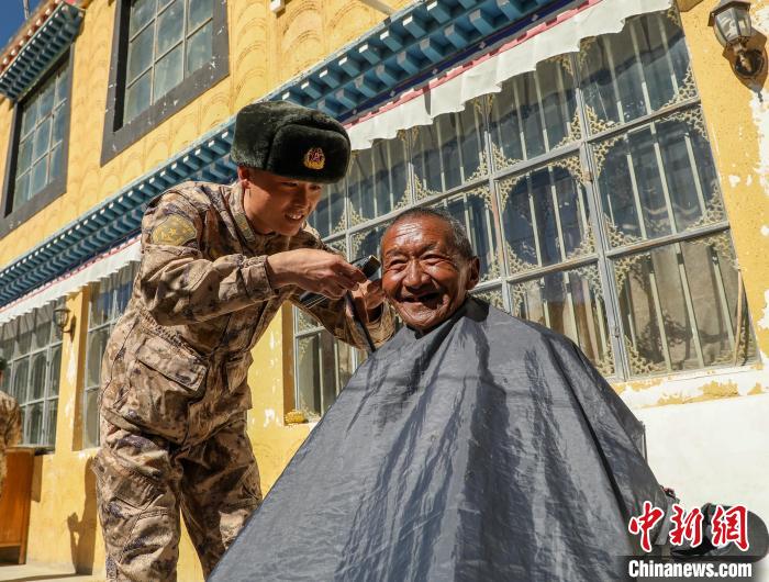 圖為阿里軍分區(qū)某邊防團(tuán)官兵為駐地群眾理發(fā)迎藏歷新年?！〉┰鰝愔?攝