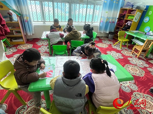 拉多村一所現(xiàn)代化幼兒園小班孩子們正在繪畫(huà)。張敏穎 攝